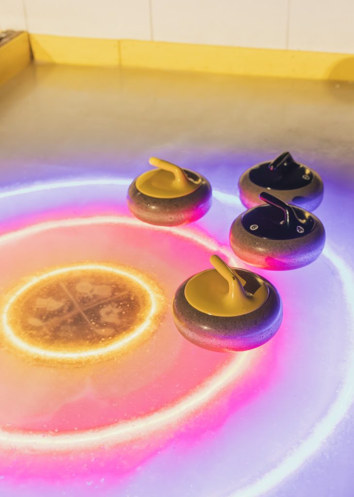 Curling stones sitting on the ice at Fox & Turtle in Itasca, Illinois, highlighting Midwest sports and travel experiences